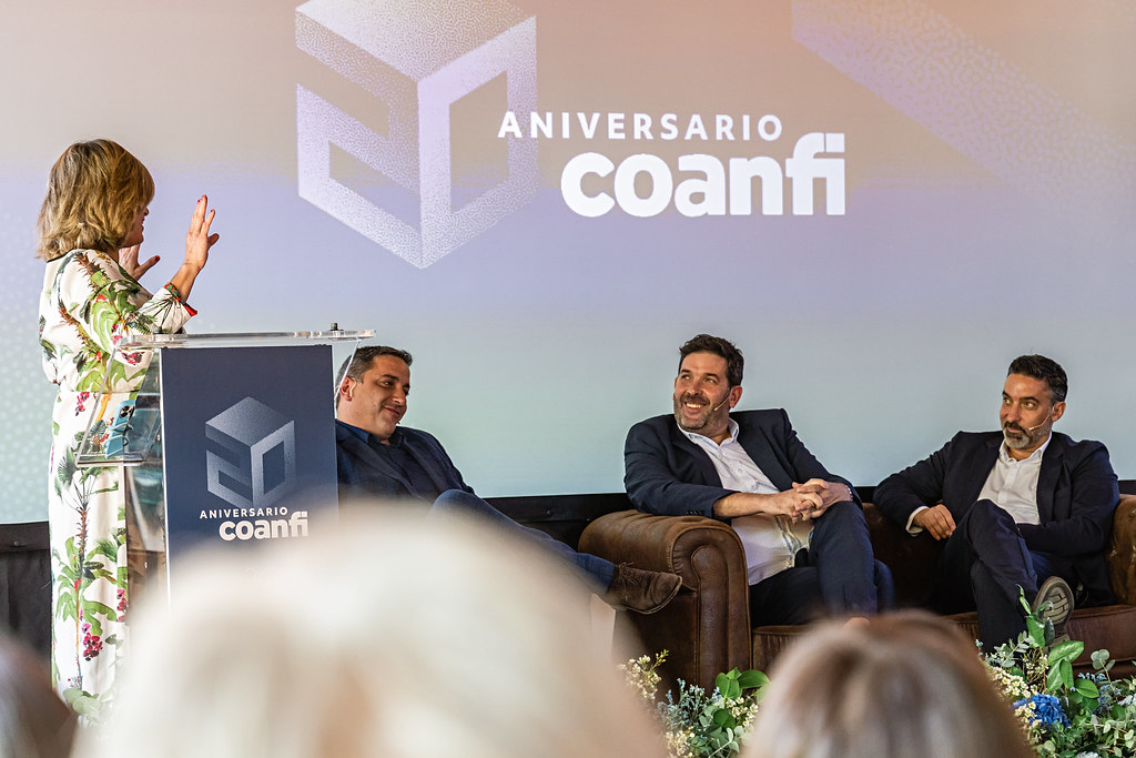 Foto del evento de coanfitrión por su 20 aniversario: la presentadora charla con los tres hermanos augusto, fundadores de la empresa